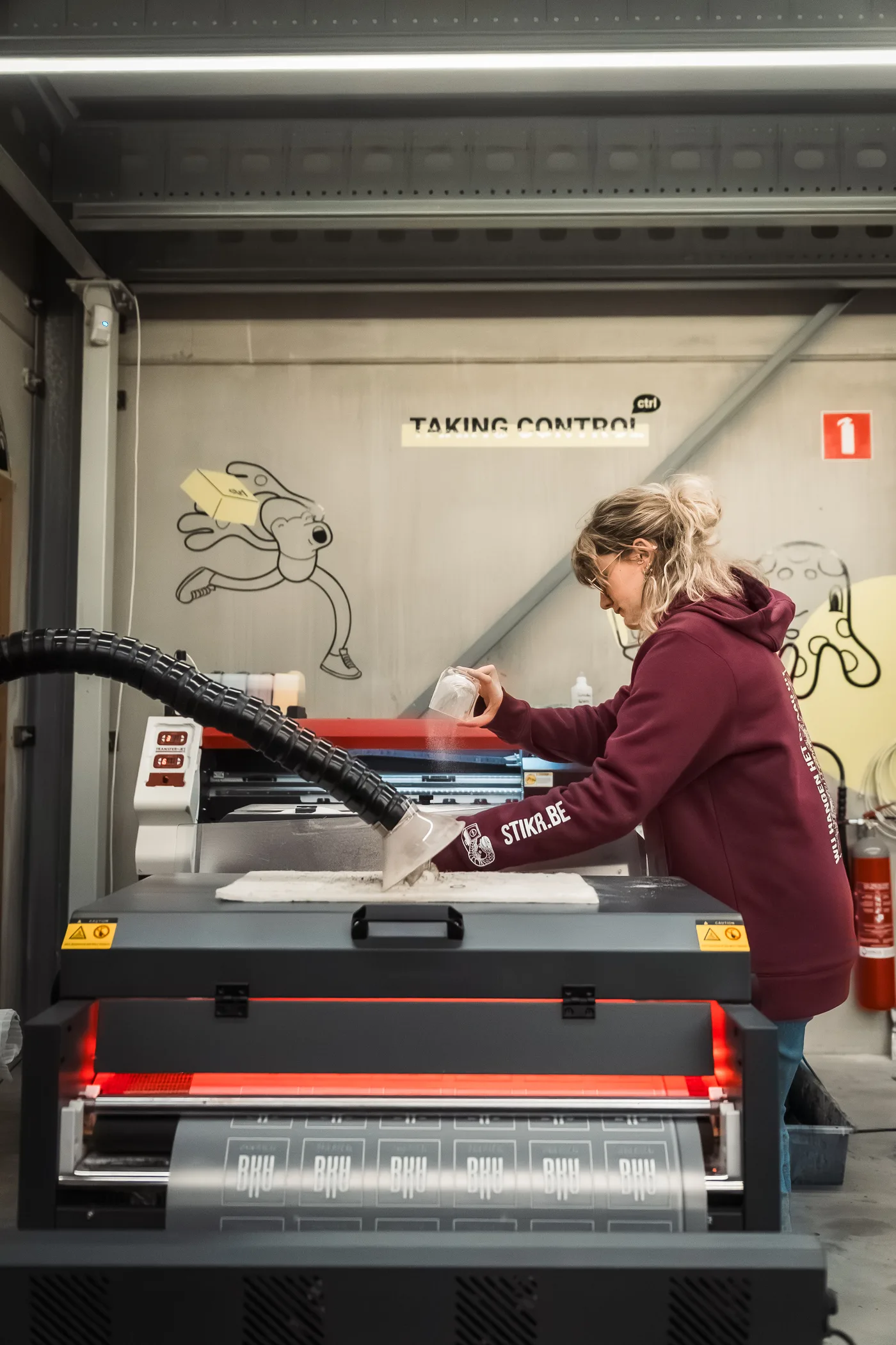 Stikr medewerker brengt een ontwerp aan op kleding met een hittepers