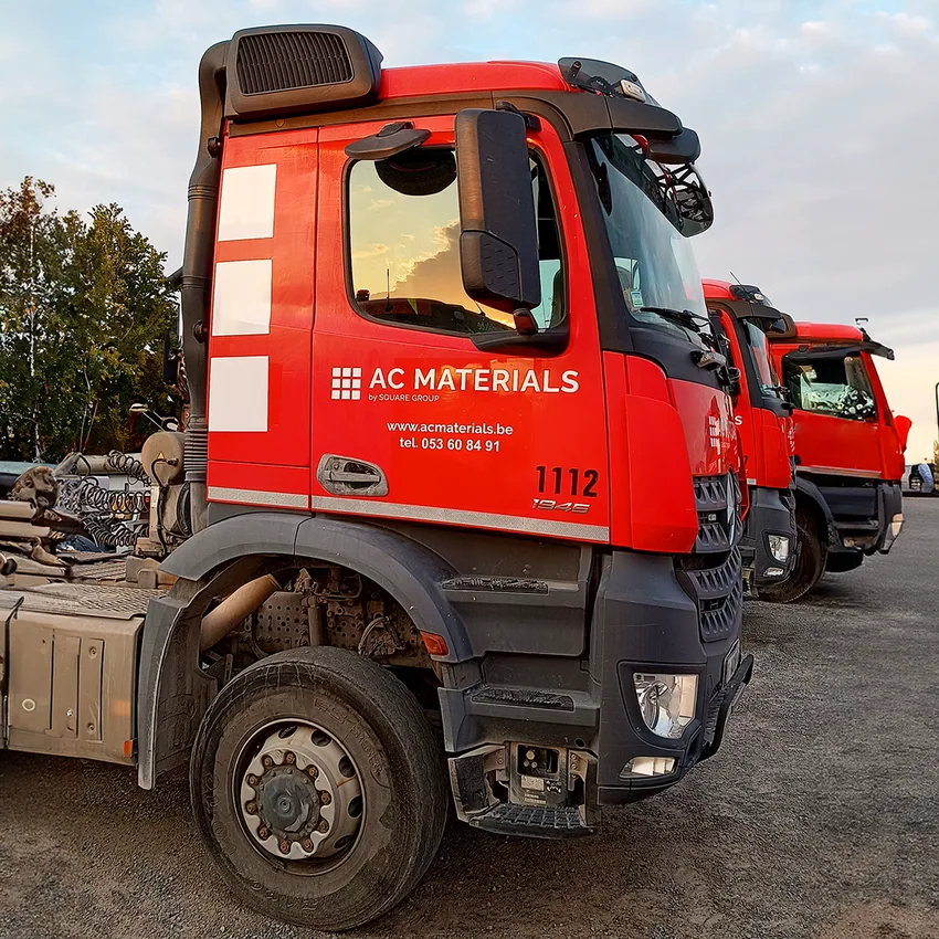 Rode vrachtwagen met AC Materials belettering