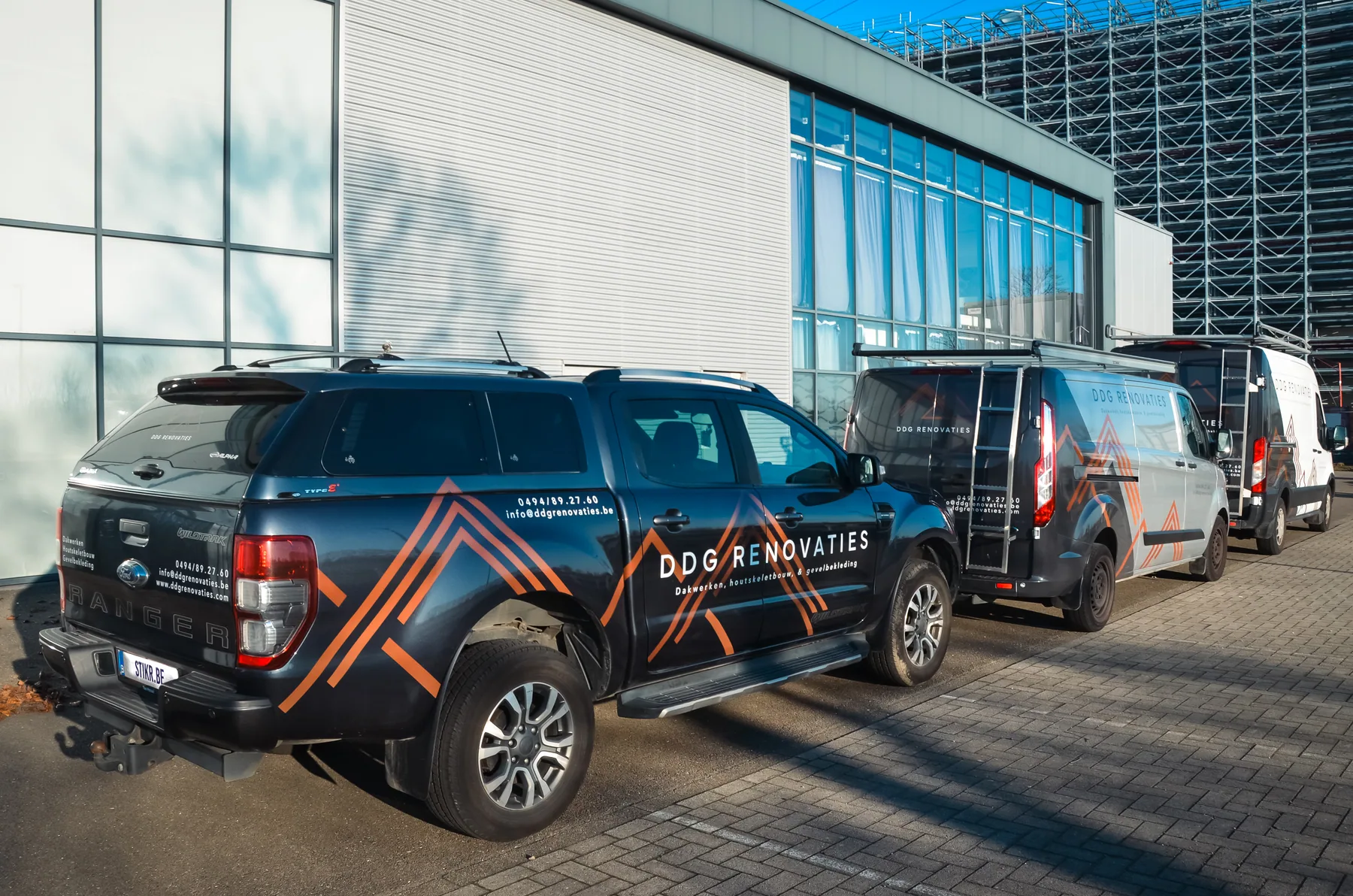 Beletterde DDG Renovaties wagenpark met pick-up en bestelwagens