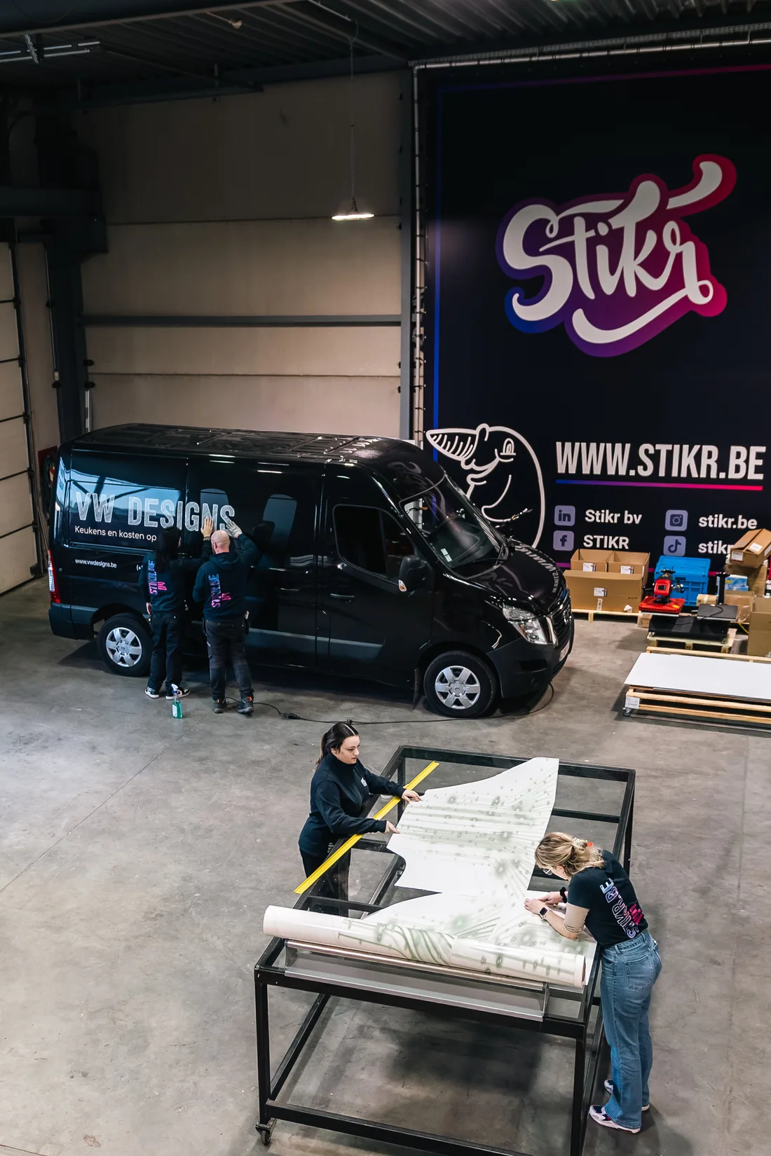 Stikr team werkt aan voertuigbelettering in het atelier