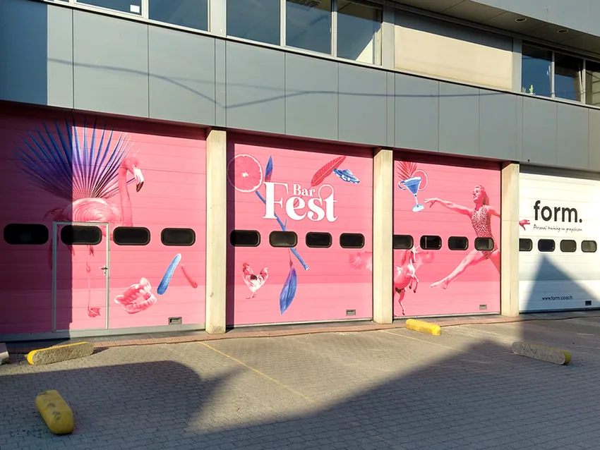 Roze belettering op de garagepoorten van Bar Fest