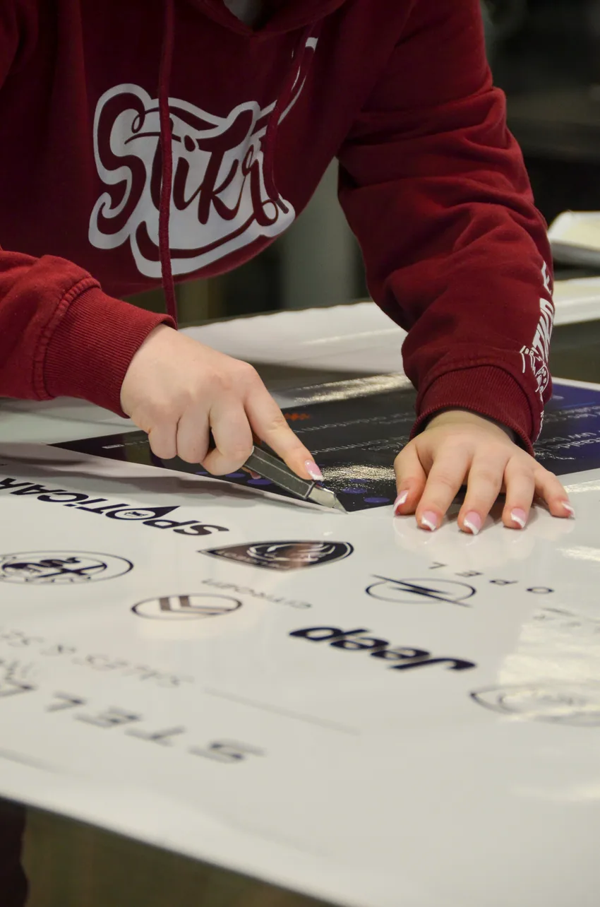 Stikr medewerker snijdt geprinte stickers op maat